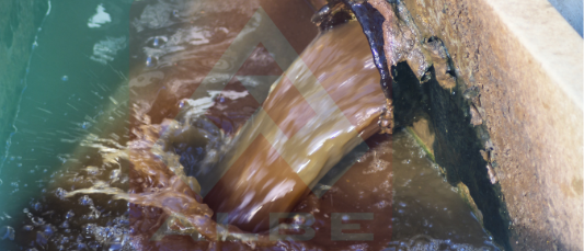 Murky water flowing from a pipe, showing the initial stage before coagulation and flocculation in water treatment begins